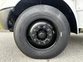 Close-up of a black tire mounted on a 2013 International 4200 truck with visible lug nuts and the brand name on the tread embossed on the sidewall