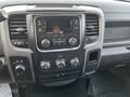 A close-up of the dashboard of a 2015 RAM 1500 showing the media control panel with radio and climate controls
