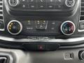 Dashboard controls of a 2023 Ford Transit featuring climate control knobs and buttons for rear defrost and air conditioning