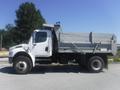 A 2005 Freightliner M2 106 Medium Duty truck with a gray dump bed visible from the side