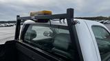 A 2013 Chevrolet Silverado 1500 with a black bed rack and an overhead light bar mounted at the rear of the cab