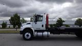 A white 2015 International DuraStar 4300 truck is shown in profile with a flatbed and visible fuel tank