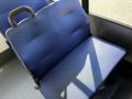 A blue upholstered seat designed for a bus or similar vehicle with a simple structure and a handle on the back