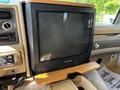A Panasonic television mounted in a 2000 Ford Motorhome with wooden accents and additional controls visible on the dashboard