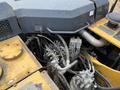 A close-up view of the engine and hydraulic system components of a 2018 John Deere 350 showing various pipes and machinery parts