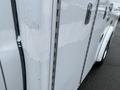 A 2016 Chevrolet Express van with a white exterior showing signs of wear and a partially scratched surface near the rear door and side panel