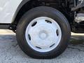 White alloy wheel of a 2019 Isuzu NRR with a black tire showing tread patterns and lug nut placements