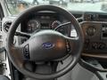 The interior of a 2011 Ford Econoline showing the steering wheel and dashboard with gauges and control knobs