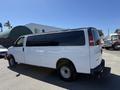 A 2007 Chevrolet Express van with a white exterior and black tinted windows, parked at an angle showing its profile and rear部分