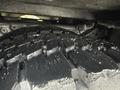 Close-up of a rugged tire tread on a 2000 Ford F-450 showing deep grooves and wet surfaces indicating recent contact with water or mud