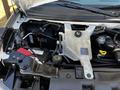 The engine compartment of a 2019 Chevrolet Express showcasing the battery coolant reservoir and various engine components