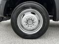 A wheel of a 2011 Ford F-550 with a silver rim and black tire featuring tread patterns and visible lug nuts