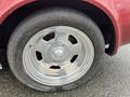 A close-up of a shiny silver wheel from a 1970 Chevrolet Corvette with a black tire showing visible tread patterns