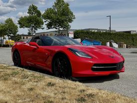 A red 2016 Chevrolet Corvette with a sleek design and black wheels parked on a paved surface