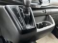 Gear shifter and cup holder inside a 2020 Ford Transit van