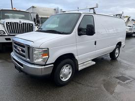 A white 2014 Ford Econoline van with a sliding side door and roof rack