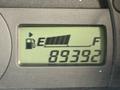 A digital fuel gauge display showing the fuel level near empty and an odometer reading of 89392 kilometers