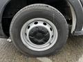 Close-up of a black wheel on a 2021 Ford Transit with a silver rim and all-season tire showing tread pattern