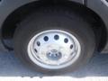 A close-up view of a tire and wheel of a 2016 Ford Transit featuring a silver rim with multiple holes and a black tire with visible tread pattern