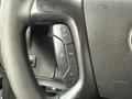 Close-up of the steering wheel controls in a 2014 GMC Savana featuring buttons for cruise control and other functions