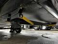 A 2022 Aspen Trail trailer showing the undercarriage with exposed metal supports and wheels visible underneath