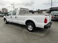 A white 2010 Ford F-250 SD with a crew cab and a flatbed featuring a metal tool rack on the back