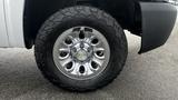 A chrome wheel with multiple spokes mounted on a large all-terrain tire from a 2013 Chevrolet Silverado 1500