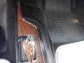 Image of the interior console of a 1974 Dodge Challenger featuring a wooden gear shift knob and a sleek design with dark materials and textures