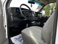 Interior of a 2015 Chevrolet Express showing the driver's seat dashboard and steering wheel with a simple gray fabric seat