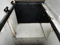 The image shows the empty interior of a storage compartment in a 2013 Ford F-650 with a blacked out back wall and metal edges