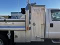 A 2008 Ford F-450 SD with a silver utility body featuring a metal door and storage compartments on the side