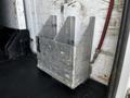 A metal bracket mounted on a surface designed to hold or secure an object, featuring a rectangular shape with cutouts and visible bolt holes