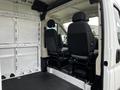 Interior of a 2021 RAM Promaster showing two black front seats and the van's empty cargo area with white walls and floor