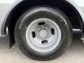 A silver wheel with a circular design mounted on a black tire labeled Bridgestone and marked as studless