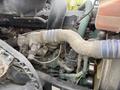 Close-up of the engine of a 2012 Volvo VNL showing various components including hoses and pipes with dirt accumulation