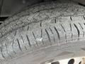Close-up of a tire from a 2023 Ford Transit showing tread patterns and some surface dust