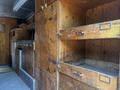 The interior of a 2008 Morgan Olson Workhorse featuring wooden cabinetry with shelves and drawers that are mostly empty and unoccupied
