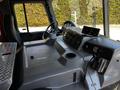 Interior of a 2006 Emergency One Fire Truck featuring a steering wheel dashboard control panel and a metal storage compartment