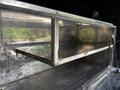 A metallic shelf inside the cargo area of a 2010 Freightliner M2 106 with a smooth surface and rectangular shape