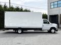 A 2021 Ford E-450 with a large white box truck body is positioned sideways showcasing its length and design