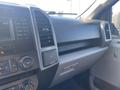Interior view of a 2017 Ford F-150 dashboard featuring a touchscreen display climate controls and a storage compartment