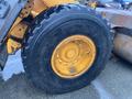 A large black tire with a yellow wheel of a 2016 Hyundai HL940 construction vehicle displaying tread patterns and bolts