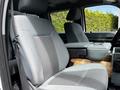The interior front seats of a 2016 Ford F-550 featuring gray fabric upholstery with a patterned design and a center armrest console