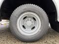 A close-up of a tire on a 2012 Ford Econoline showing detailed tread patterns and a silver rim with six lug nuts