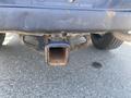 A close-up of the hitch receiver on a 2021 RAM 1500 showing rusted edges and a square opening for towing equipment