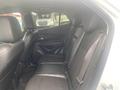 A 2018 Buick Encore's rear interior showing two rows of black leather seats with door handles and a window in the background