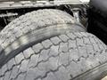 Close-up of two large, worn truck tires mounted on a 2012 Volvo VNL highlighting the tread pattern and wear on the rubber surface