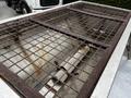 A 2011 Ford F-550 with a rusted metal grate on the truck bed showing signs of wear and aging