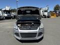 A silver 2014 Ford Escape with the hood raised showcasing the engine compartment