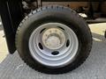 A close-up of a 2021 Ford F-550 wheel featuring a silver rim with a central hub and black tire marked with the specifications 225 70R 19.5